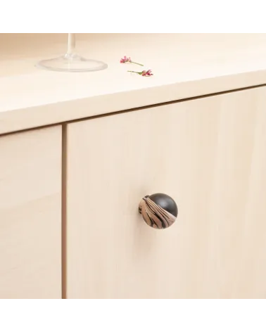 Black chino beech wood furniture knob design handle close-up view mounted on a chest of drawers