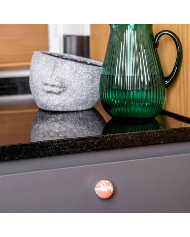 Cherry red beech wood furniture knob design handle fixed on a grey cabinet front beneath a worktop