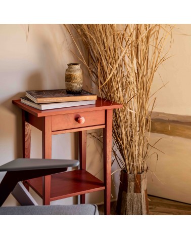 Cherry red beech wood furniture knob design handle installed on a wooden cabinet with dried flowers