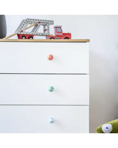 Cherry red beech wood furniture knob design handle installed on a white chest of drawers