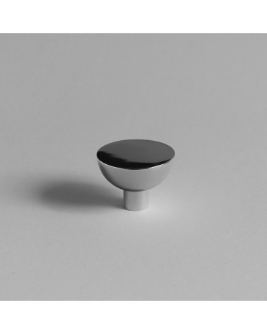 LUNA M polished chrome furniture knob placed on a grey surface