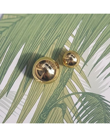 Polished gold ODETE furniture knob, designer handle placed on a patterned background