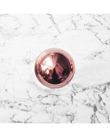 Copper ODETE M furniture knob, designer handle, top view on a marble surface