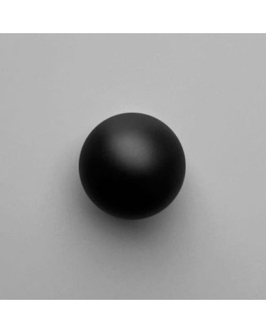 Brass ODETE BLACK M furniture knob, designer handle, front view on a light surface