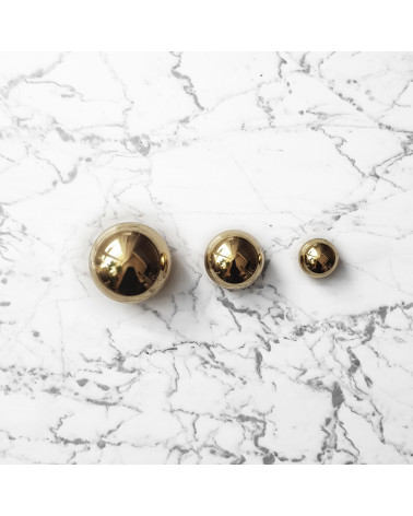 ODETE polished brass cabinet knob designer handle placed on a marble background