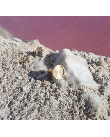 INA brass furniture knob design handle positioned on sandy surface