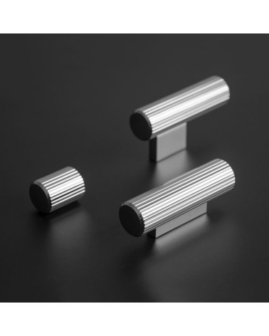 Polished chrome AVANTI furniture knob designer handle placed on a dark surface