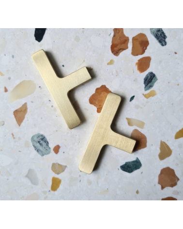 ISA T brass furniture knob design handle top view placed on a patterned plate