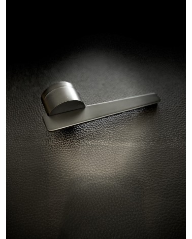 JUMELLE black door handle design handle placed on a dark background