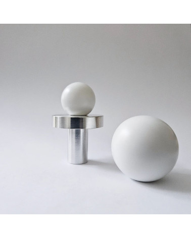 POLA WHITE designer furniture knob in brass arranged on a background in close-up