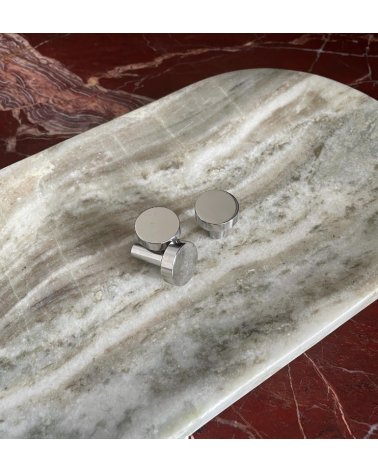 Polished chrome NENA furniture knob designer handle placed on a marble surface
