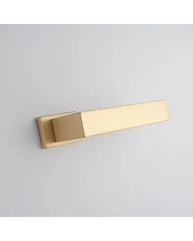 Matt gold door handle PINA design handle bottom angled view mounted on a door