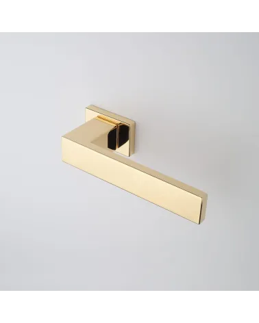 PINA polished gold door handle design angled top view mounted on a door