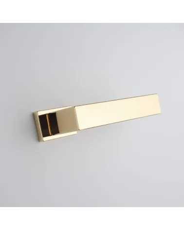 Polished gold door handle PINA design handle angled bottom view mounted on a door