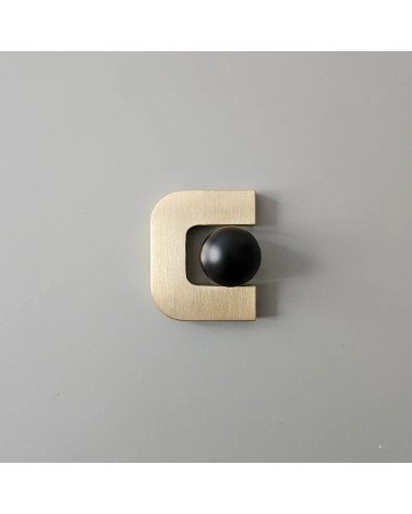 Polished gold ISA XS furniture handle designer handle with black sphere placed inside opening