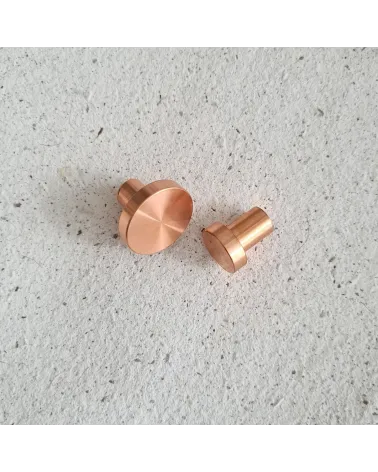 Brass NENA furniture knob design handle positioned side by side on a flat surface