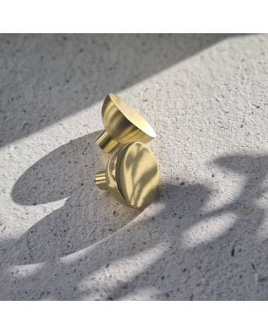 LUNA M polished gold furniture knob design placed on cement