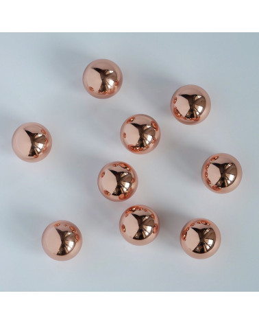 ODETE M copper furniture knob design arranged randomly on a white surface with shiny reflections