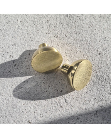LUNA M polished gold furniture knob design handle zoomed view placed on a textured plate