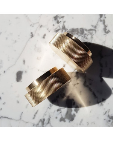 Matte gold TOVE furniture knob designer handle angled top view on a white marble surface with shadows