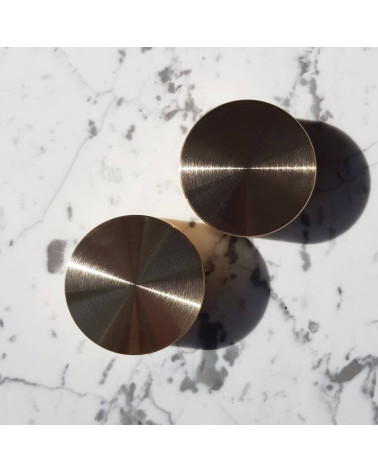 Matte gold TOVE furniture knob designer handle placed on a white marble surface