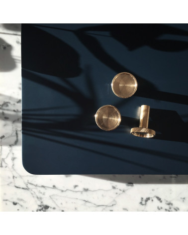 Brass VERA furniture knob designer handle placed on a black table