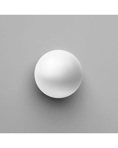 White ODETE furniture knob design handle top view placed on a grey surface