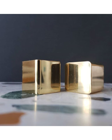 Brass ODETE furniture knob LANA S design handle front view placed on a marble surface with touches of colour