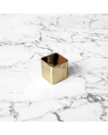 Brass ODETE furniture knob LANA S design handle tilted top view placed on a marble surface