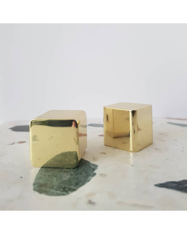 Brass ODETE furniture knob LANA S design handle placed on a patterned stone surface