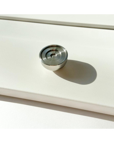 Stainless steel furniture knob model 02 design handle placed on an illuminated surface casting a shadow