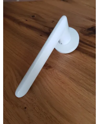 White Spark designer door handle angled top view placed on a plate