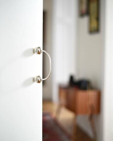 Brass furniture handle 10 designer handle fixed on a door with a blurred background