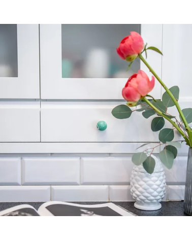 Rich green beech wood furniture knob designer handle mounted on a piece of furniture with roses on top