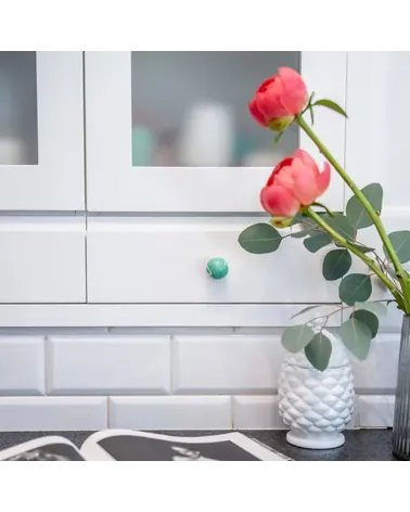 Rich green beech wood furniture knob designer handle mounted on a piece of furniture with roses on top