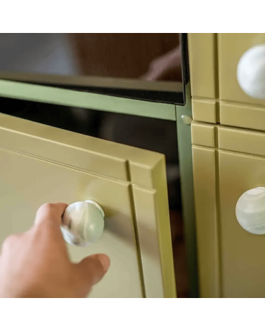 Mistel beech wood furniture knob designer handle fixed on an open door held by a hand