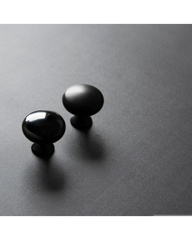 TORONTO furniture knob designer handles positioned diagonally on a dark surface