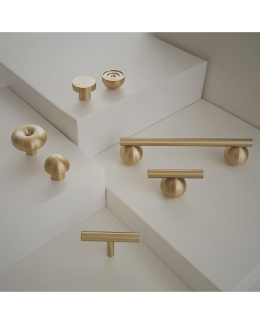 Brass furniture knob model 04 design handle placed on a light stepped surface