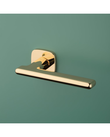 MARANTA polished brass door handle design handle fitted on a coloured background