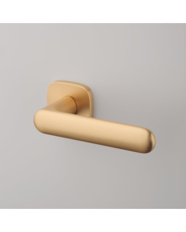 Matt gold OLEA door handle designer handle inclined top view fixed on a background