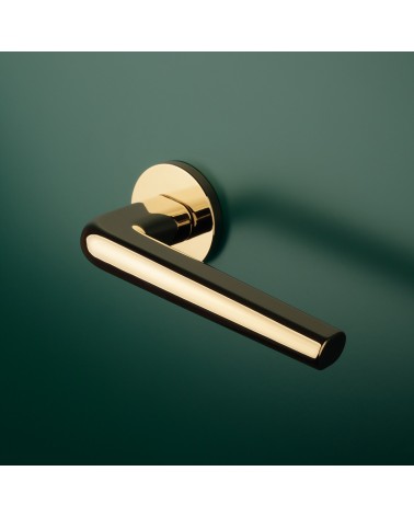 FUNKIA polished gold designer door handle mounted on a door